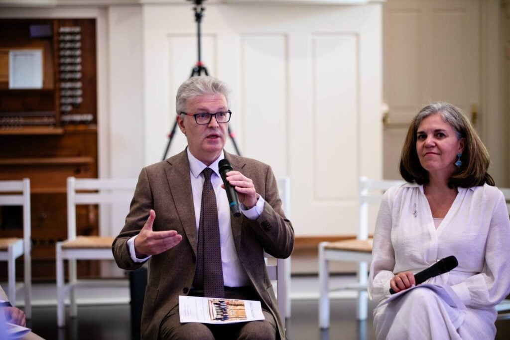 Margarita Mooney Clayton with Sir James MacMillan speaking on a panel at an event.